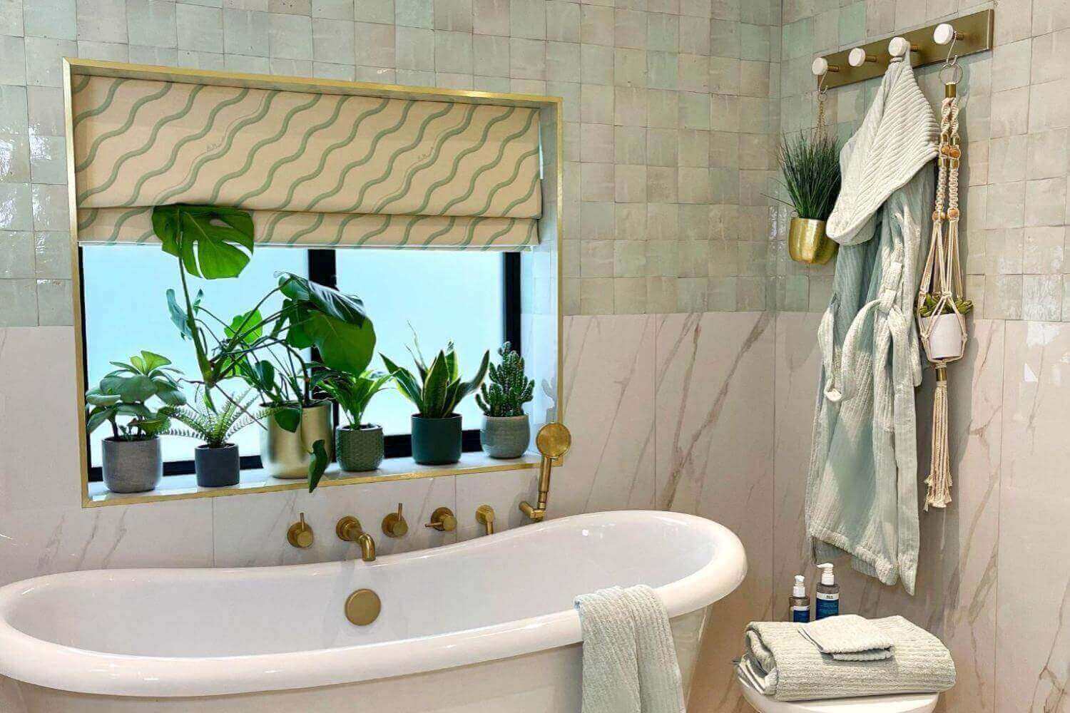 Tranquil bathroom with a freestanding tub, plants, and soft decor for a spa-like atmosphere.