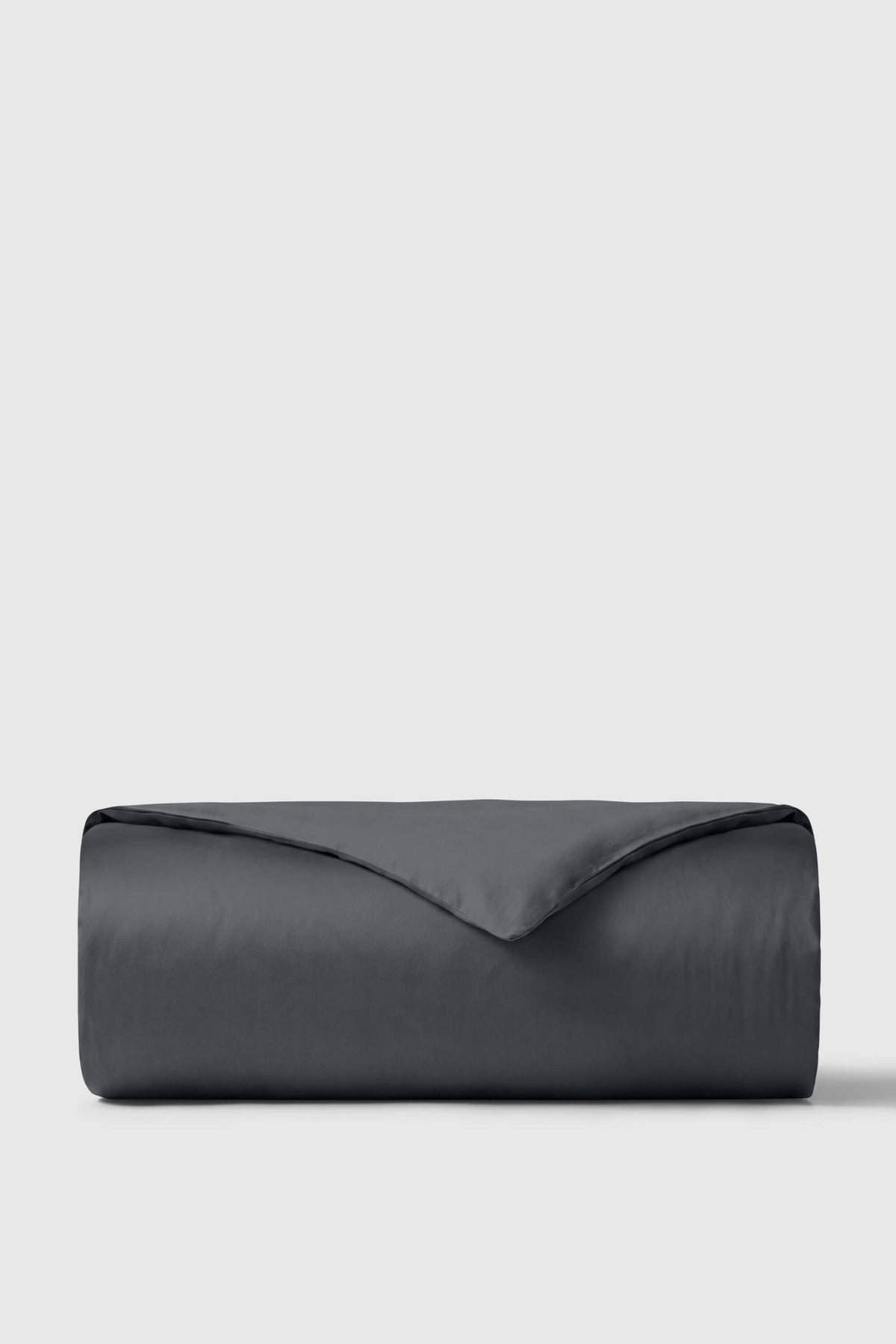 Folded dark grey sateen duvet cover on a plain light grey background