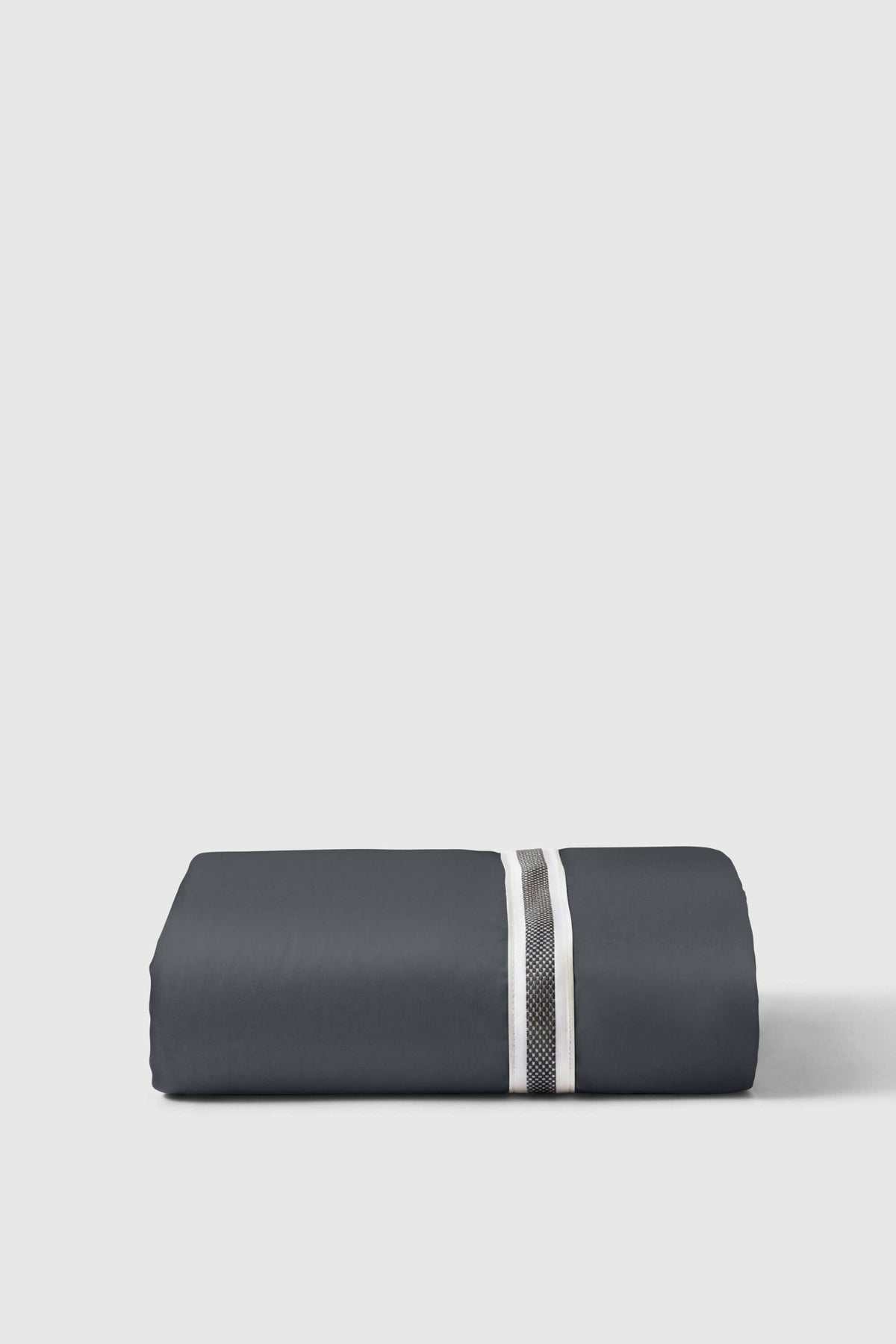 Extra deep fitted sheet in dark grey sateen, folded with its striped elastic edge on top
