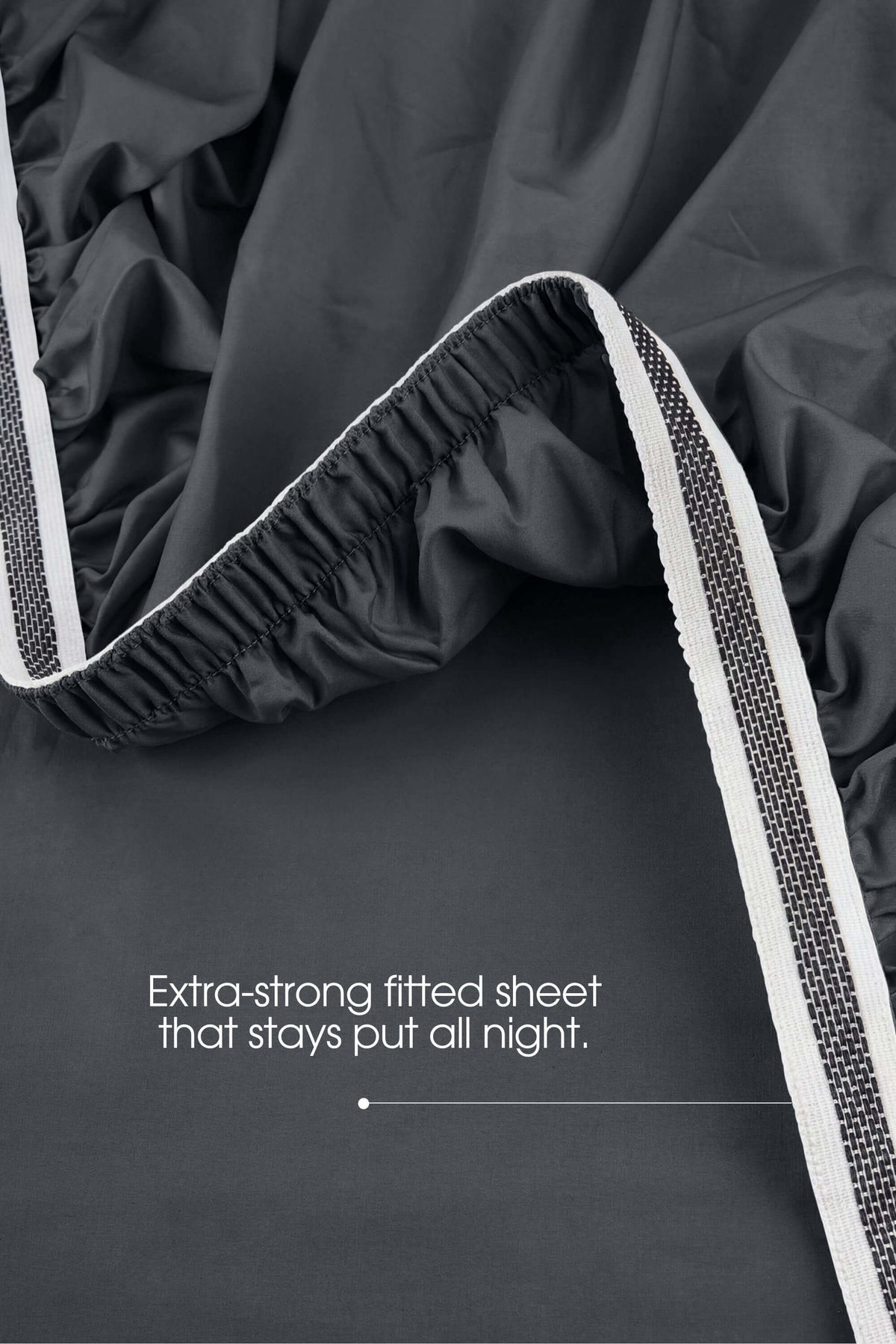 Elastic grip detail on the corner of a dark grey sateen extra deep fitted sheet