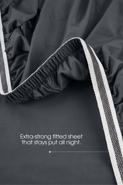 Elastic grip detail on the corner of a dark grey sateen extra deep fitted sheet