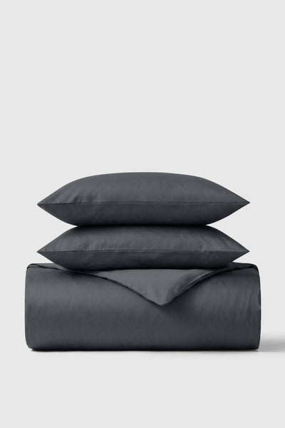 Folded dark grey sateen duvet cover topped with two matching pillowcases